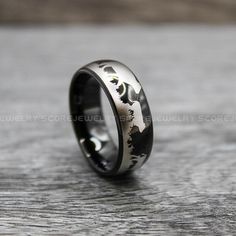 a black and silver ring with an image of a man on it's side