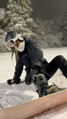 a snowboarder is sitting in the snow with her board attached to her feet