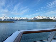 the mountains are covered in snow as seen from a cruise ship's bow deck