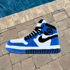 a pair of blue and white sneakers sitting next to a swimming pool