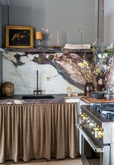 a kitchen with marble counter tops and an island in front of a stove top oven