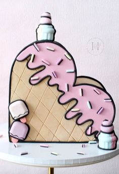 a cake shaped like an ice cream cone with pink icing and sprinkles