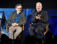 two men sitting in chairs talking to each other