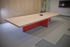 a large wooden table in the middle of a room with carpeted floors and walls