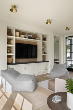 a living room filled with furniture and a flat screen tv mounted on a wall above it