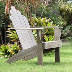 a wooden chair sitting on top of a lush green field