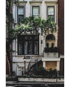 an apartment building with many windows and plants growing on the balconies, next to a street light