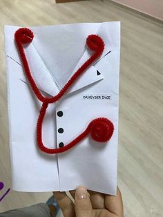 someone is holding up a paper card with a stethoscope on it that has been made to look like a doctor's coat and tie