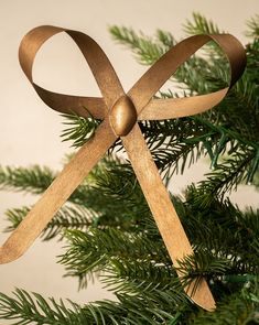 a wooden ornament hanging from a christmas tree with ribbon on it's end