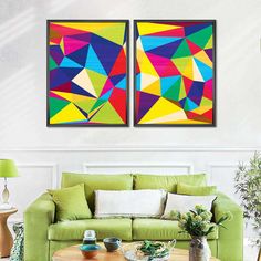 two colorful paintings on the wall above a green couch in a living room with white walls