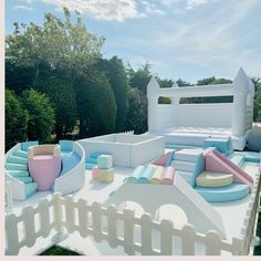 an inflatable play area is shown with colorful cushions and pillows on the ground