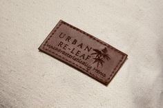 a label on the back of a shirt that says urban releaving, with palm trees in the background