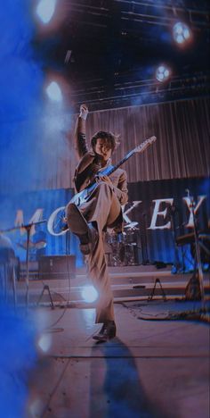 a man is performing on stage with his guitar