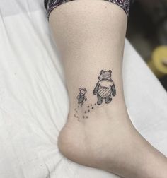 a small winnie the pooh tattoo on the ankle is shown in black and white