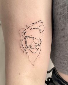 a woman's arm with a small tattoo of a lion on the left side