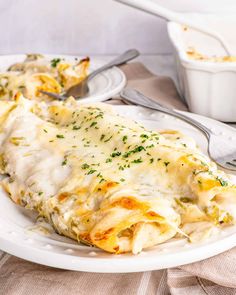 a white plate topped with lasagna covered in cheese