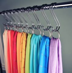 a rack with towels hanging from it's sides and rainbow colors in the background