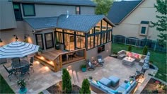 an aerial view of a backyard with patio furniture and lights on the deck, as seen from above