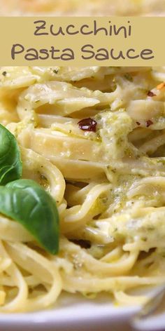 a plate of pasta with pesto sauce and basil garnish on top, in front of a sign that reads zucchini pasta sauce