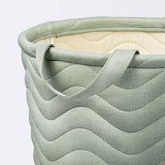 a close up of a green fabric basket with handles on the bottom and inside,