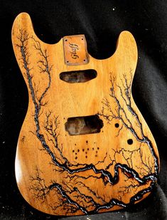 an electric guitar with tree branches carved on it's body and the pick - up plate