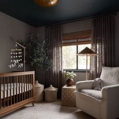 a baby's room with a crib, rocking chair, and large window