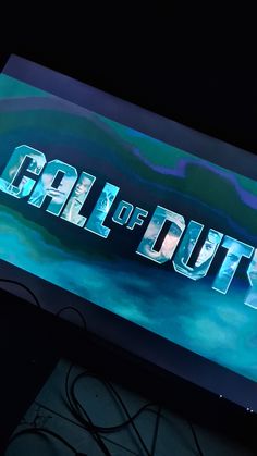 the logo for call of duty is displayed on a large screen with wires in front of it