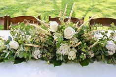 the table is set with flowers and greenery