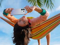 a woman laying in a hammock taking a selfie