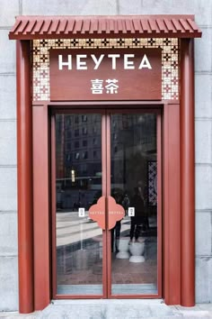 the entrance to heytea is decorated with red and gold designs on it's doors