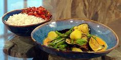 two bowls filled with food sitting on top of a table