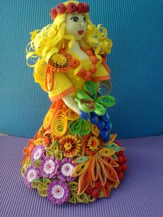 a colorful doll made out of paper flowers