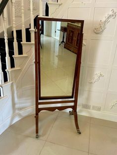 a mirror sitting on top of a wooden stand in front of a stair case next to a banister