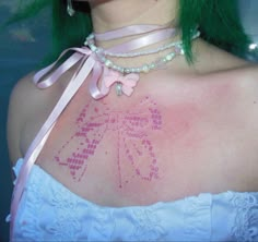 a woman with green hair and tattoos on her chest