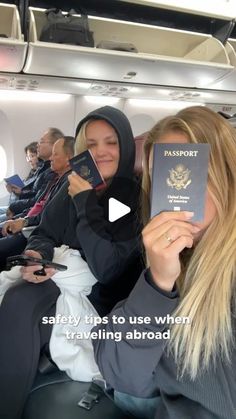 two women sitting on an airplane holding up their passport