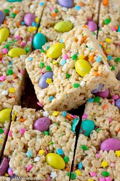 rice krispy treats are stacked on top of each other with colorful candies around them