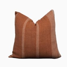 a brown and white striped pillow on a white background