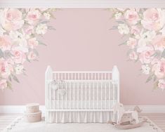 a baby's room with pink and white flowers on the wall