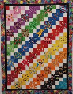 a multicolored quilt hanging on the wall