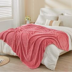 a bed with a pink blanket on top of it