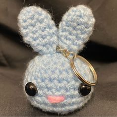 a small crocheted keychain with a bunny face on it's side