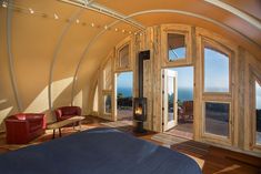 a bedroom with wooden walls and windows overlooking the ocean is pictured in this 360 - angle photo