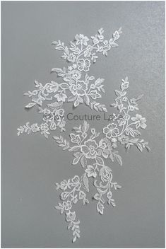 some white flowers and leaves on a gray background with the words couture lace