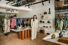 a woman standing in front of a clothing rack