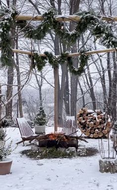 an outdoor fire pit surrounded by snow covered trees