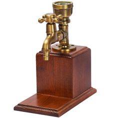 an old fashioned brass faucet on wooden stand