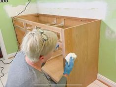 a man with blue gloves is cleaning the cabinets