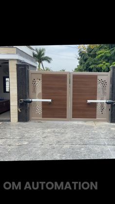 an automatic gate installed in front of a house with the words om automation on it