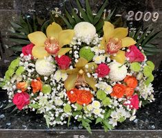 a bouquet of flowers sitting on top of a black marble table next to a marker