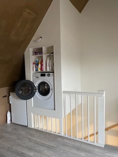 a washer and dryer are in the corner of a room with white walls